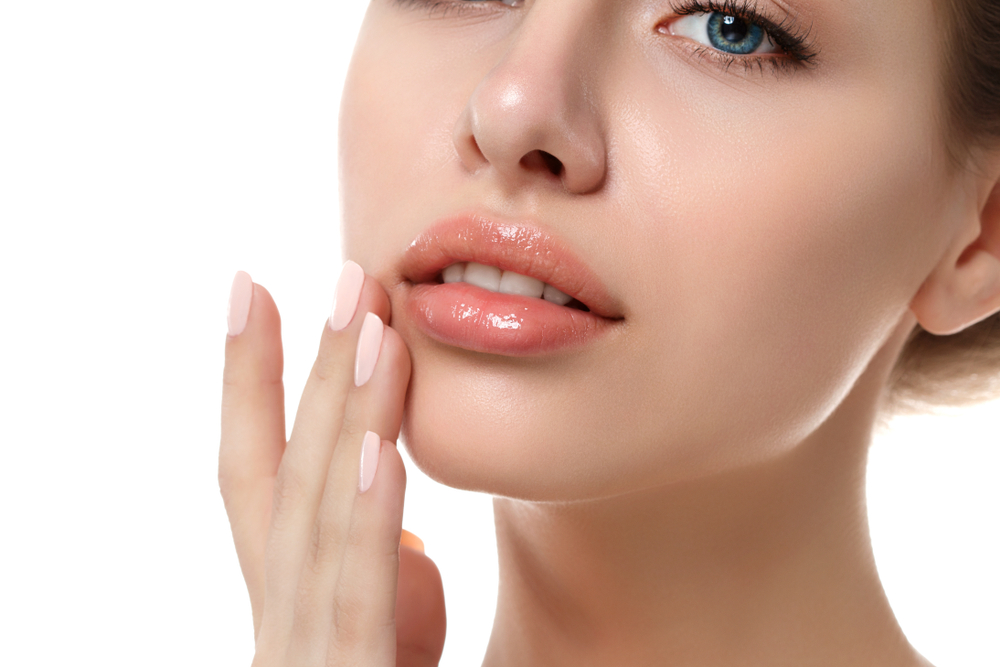 Woman touches her lips, showcasing results of a precise Botox treatment.