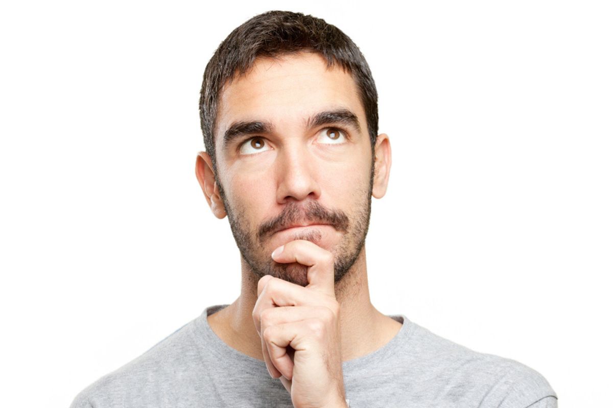 Pensive man thinking about hair restoration financial aspects.