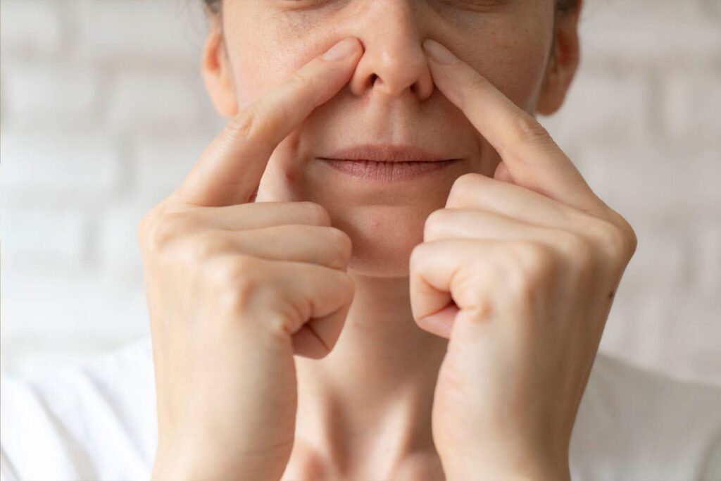 woman feeling her nasal obstruction before getting a functional rhinoplasty in Miami, FL